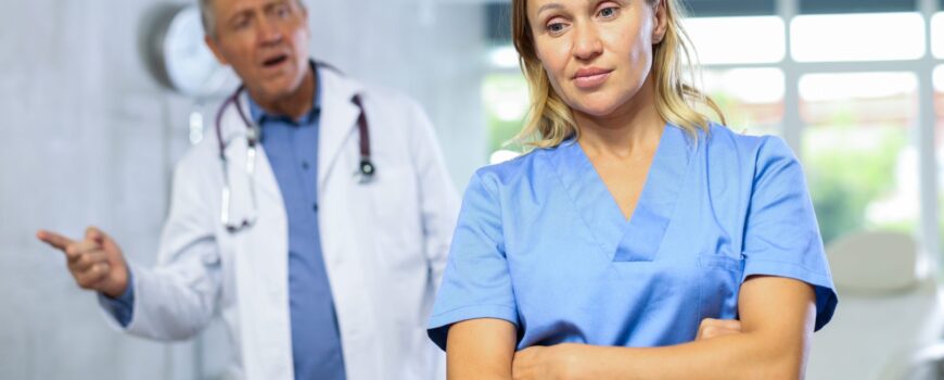 Frustrated,Female,Doctor,Standing,With,Crossed,Arms,In,Medical,Office